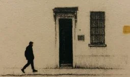 a man in a red face mask walking past a building 